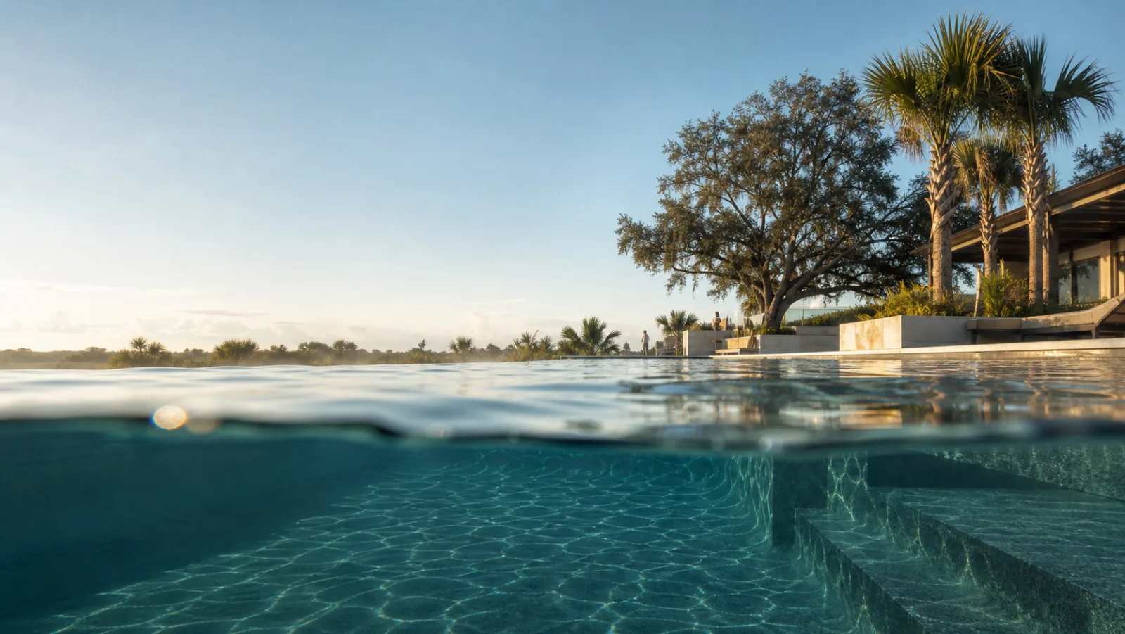 Infinity-edge pool at dawn, seen from the waterline